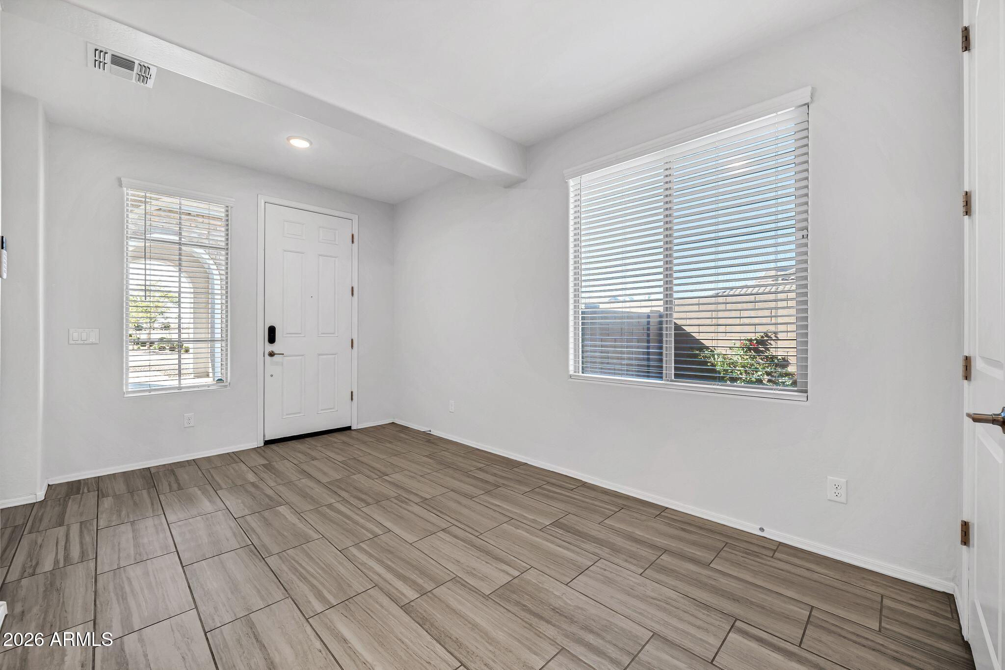 14384 West Hearn Road Surprise, AZ 85379 - Photo 6 of 63 a view of an empty room with wooden floor and a window