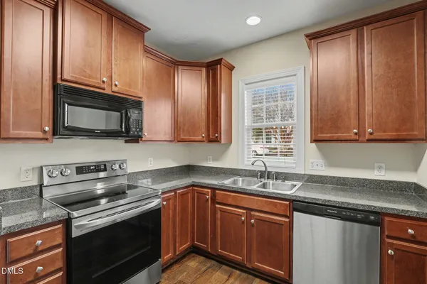 a kitchen with stainless steel appliances granite countertop a sink stove and microwave