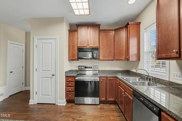 a kitchen with stainless steel appliances granite countertop a stove a sink and a microwave