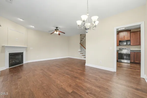 a view of a livingroom with a fireplace a chandelier and wooden floor