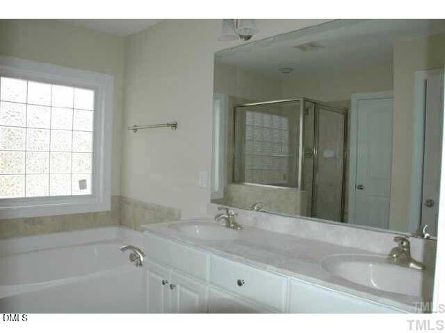 242 Sugar Maple Avenue Wake Forest, NC 27587 - Photo 6 of 7 a bathroom with a tub sink and mirror