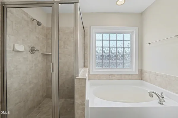 a white bath tub sitting next to a shower