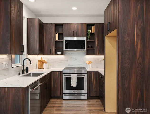 a kitchen with stainless steel appliances granite countertop a sink stove and refrigerator
