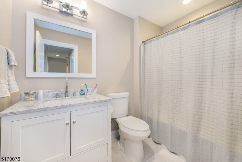 6 Elm Street, Unit 10 Madison, NJ 07940 - Photo 11 of 15 a bathroom with a granite countertop sink toilet and mirror