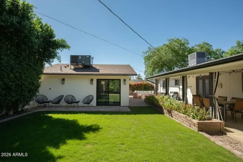 a front view of house with garden and trees in the background