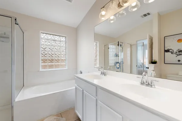 a bathroom with a sink double vanity granite tub and a mirror