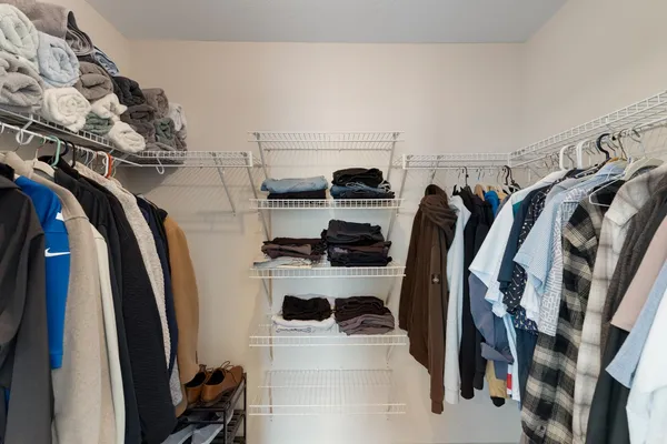 a view of walk in closet with clothes and shoes