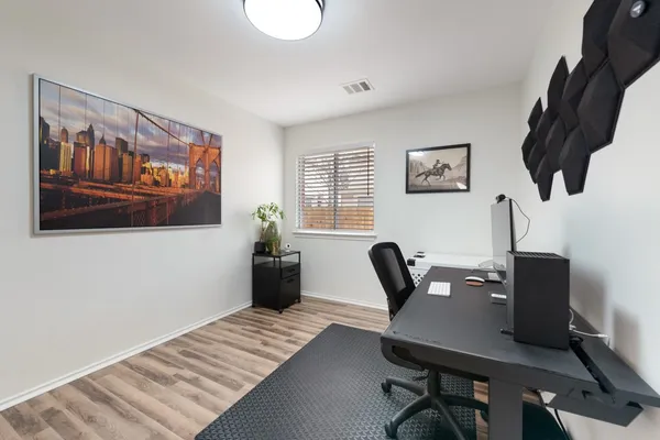a view of a workspace with furniture and a window