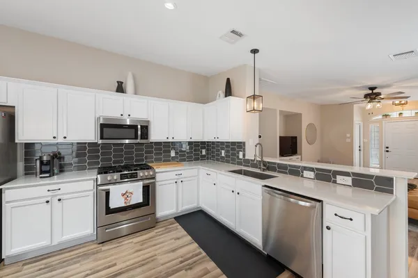 a kitchen with stainless steel appliances a sink stove and cabinets