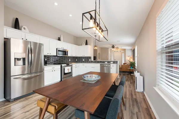 a kitchen with granite countertop a refrigerator a stove a sink dishwasher and wooden floor