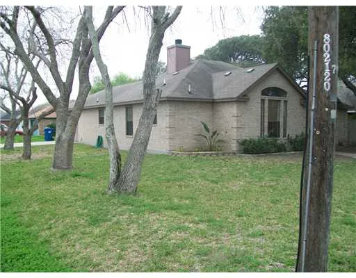 a view of a house with a yard and a tree