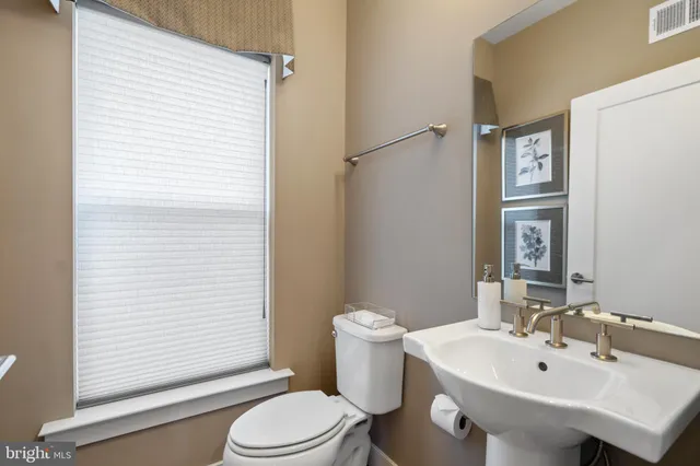 a bathroom with a granite countertop sink a toilet a mirror and shower