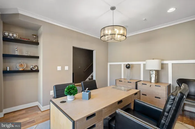 a view of a hallway with front door wooden floor and cabinet