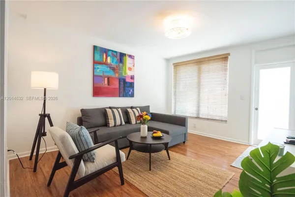 a living room with furniture and a wooden floor