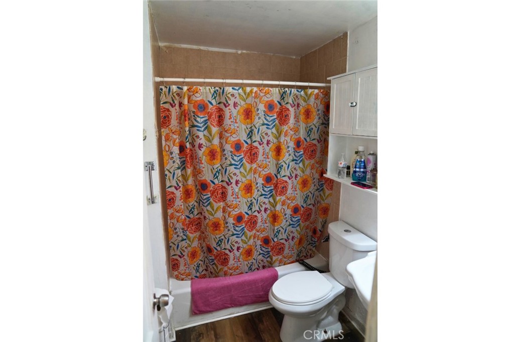 10924 Rincon Drive Whittier, CA 90606 - Photo 21 of 27 a white toilet sitting next to a shower curtain