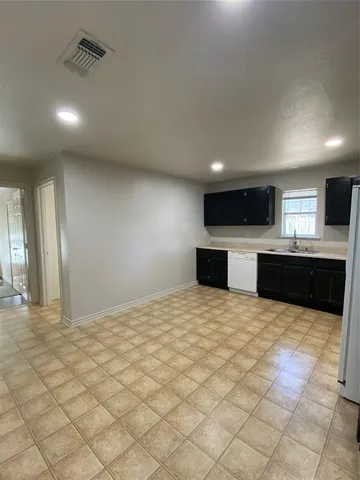 a large kitchen with a stove and a view of living room
