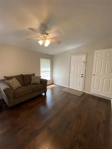 a living room with furniture and a ceiling fan