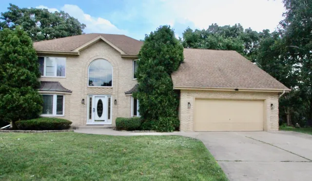 a front view of a house with a yard and garage