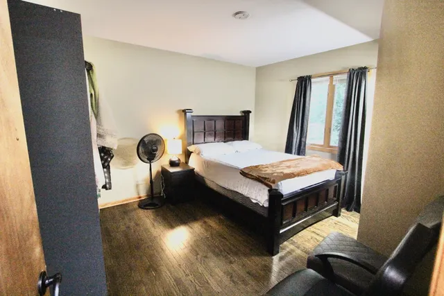 a bedroom with a bed and wooden floor