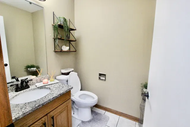 a bathroom with a granite countertop sink a toilet and a mirror