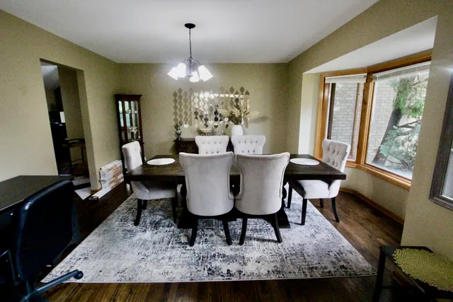 a dining room with furniture a chandelier and wooden floor
