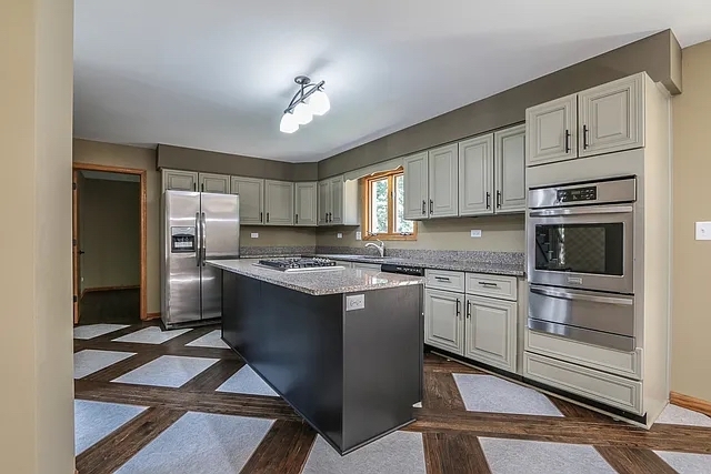 6 Allegheny Court Bolingbrook, IL 60440 - Photo 7 of 38 a kitchen with stainless steel appliances granite countertop a stove refrigerator and cabinets