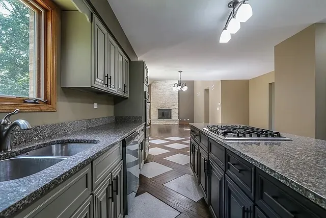 a kitchen that has a sink a stove and a wooden cabinets