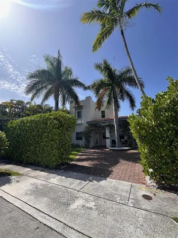 front view of a house with a palm tree