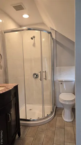 a bathroom with a shower a toilet and a sink
