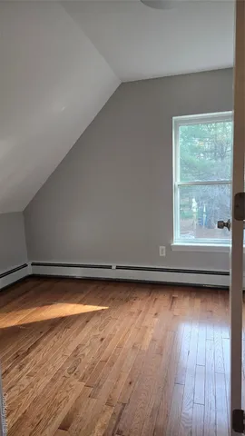a view of a room with wooden floor and a window
