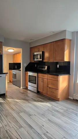 a kitchen with stainless steel appliances wooden cabinets and a counter top space