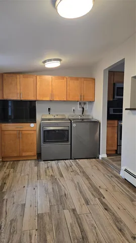 a kitchen with wooden floors and white cabinets