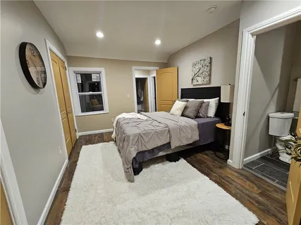 a bedroom with a bed a mirror and dresser