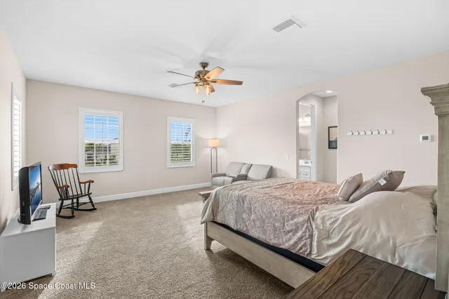 a bedroom with a bed a chair and a couch