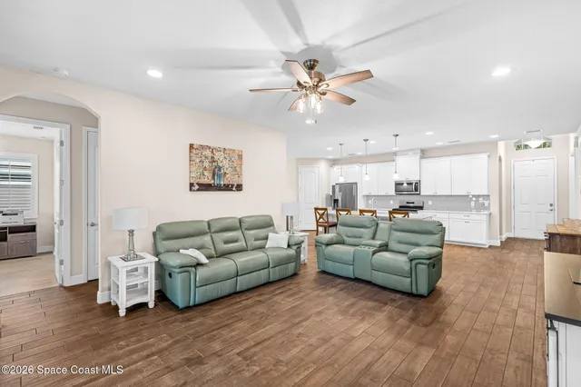 a living room with furniture and a view of kitchen