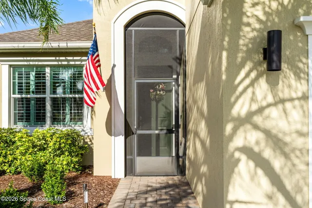 a view of a door of the house with a potted plant