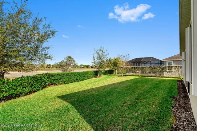 a view of yard with swimming pool and green space