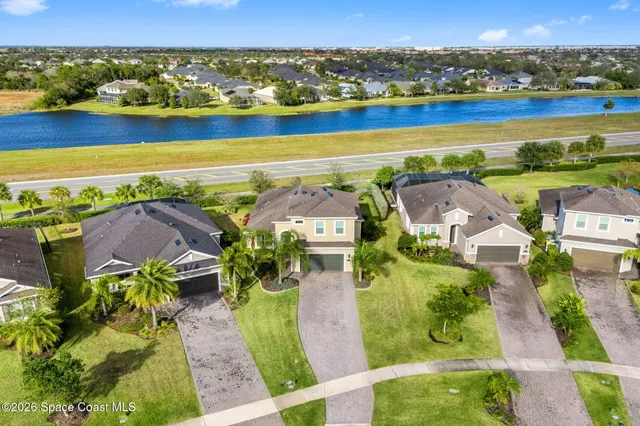 an aerial view of residential houses with outdoor space and ocean view