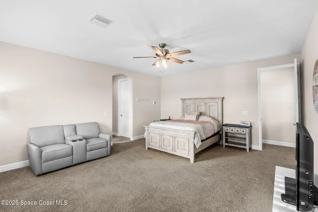 a spacious bedroom with a bed and a couch