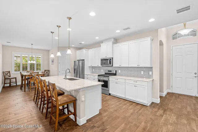 a large kitchen with kitchen island a sink table and chairs