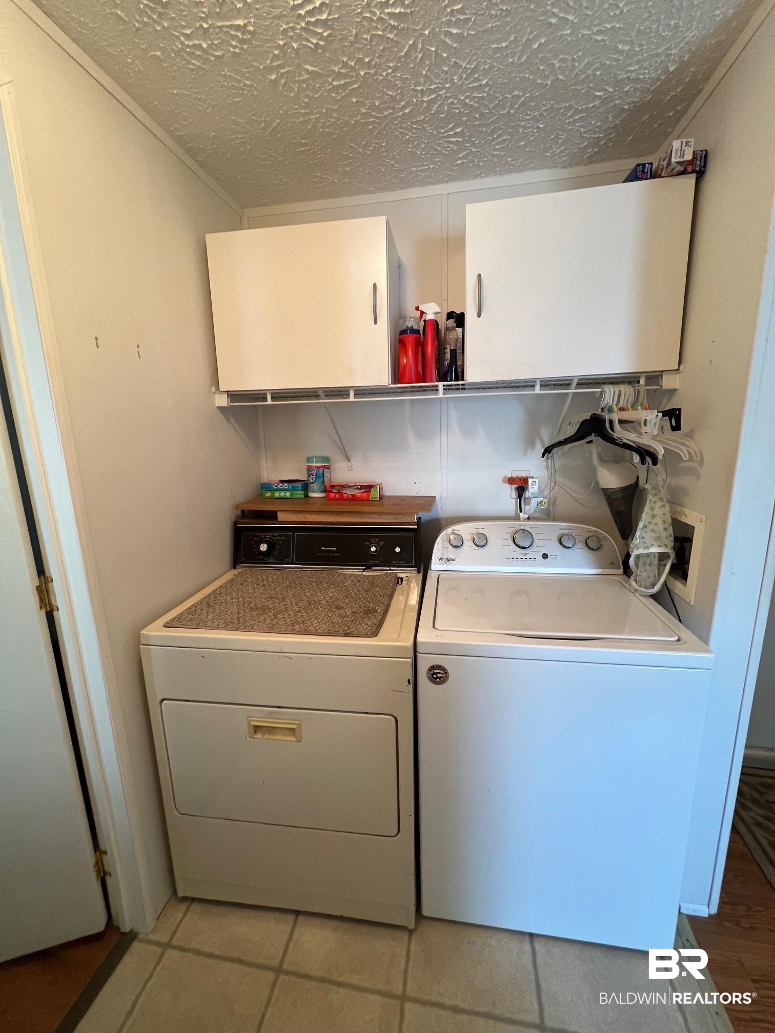 1936 Ridgewood Drive Lillian, AL 36549 - Photo 9 of 30 Clothes washing area with cabinet space, washer and dryer, and a textured ceiling