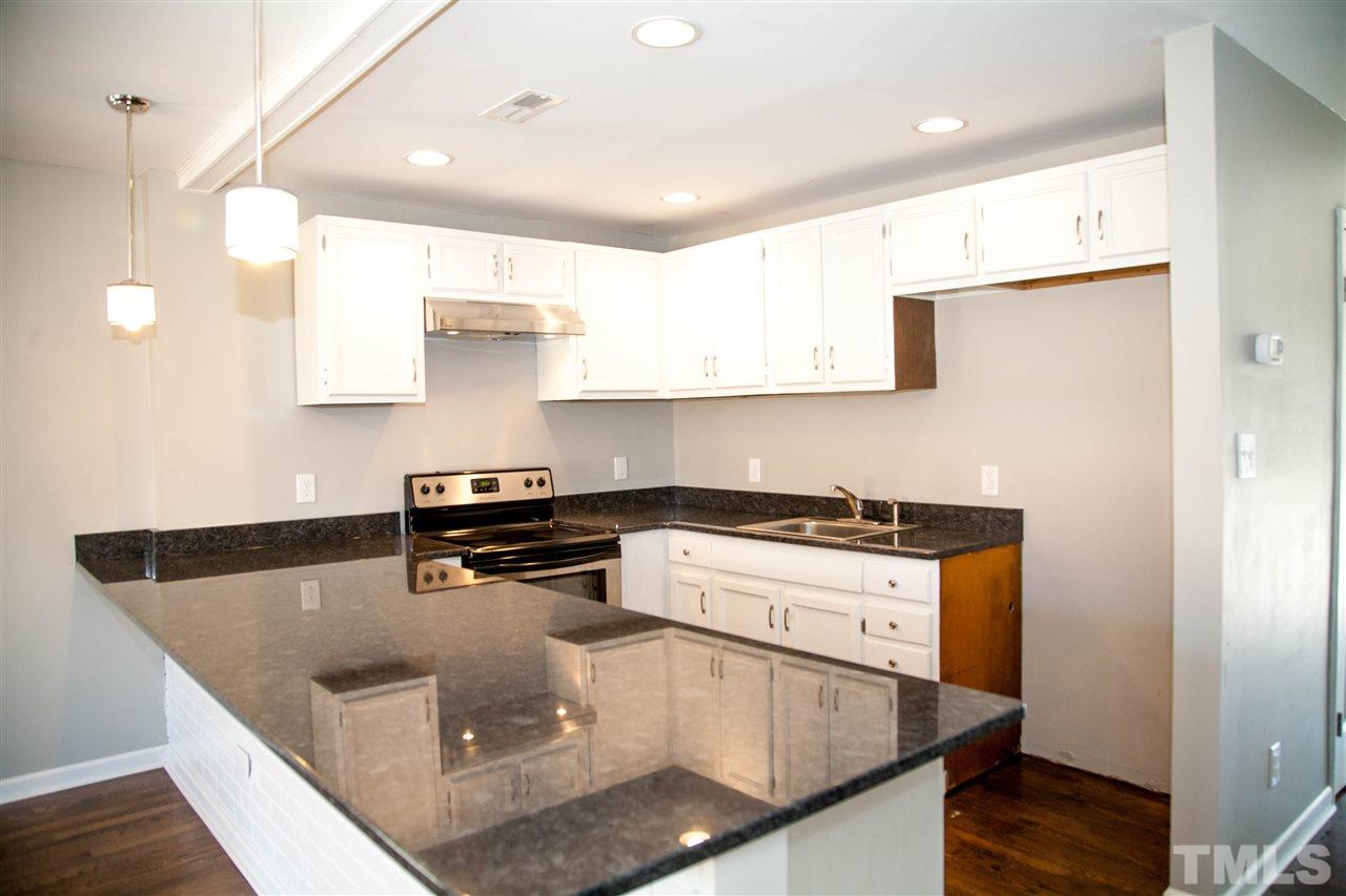 833 Newcombe Road Raleigh, NC 27610 - Photo 6 of 25 a kitchen with stainless steel appliances granite countertop a sink a stove and a refrigerator