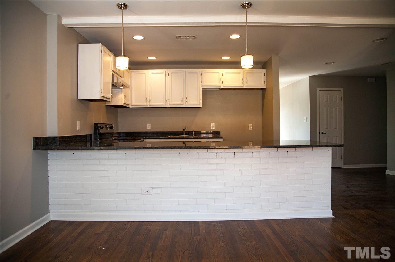 833 Newcombe Road Raleigh, NC 27610 - Photo 7 of 25 a view of a kitchen with a stove and wooden floor