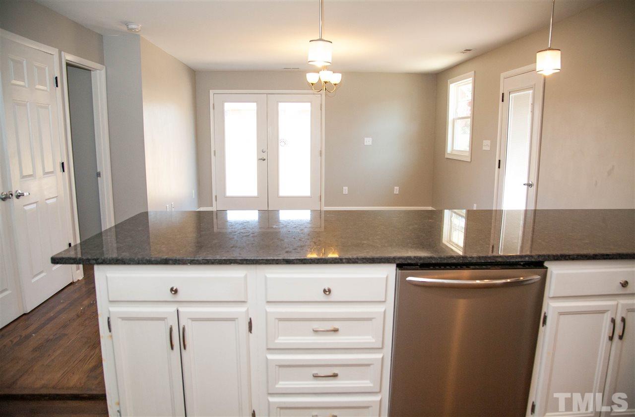 833 Newcombe Road Raleigh, NC 27610 - Photo 8 of 25 a kitchen with granite countertop a sink and a refrigerator