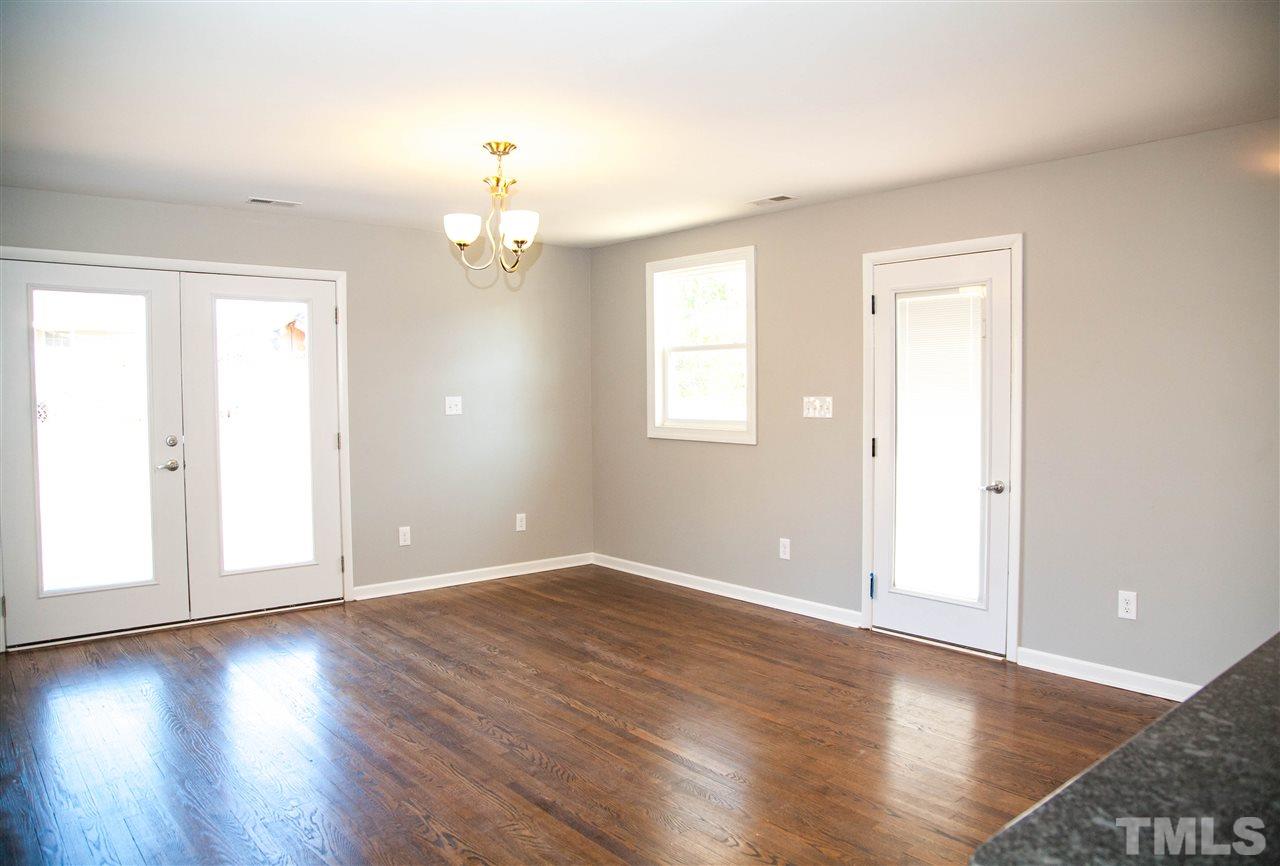 833 Newcombe Road Raleigh, NC 27610 - Photo 10 of 25 an empty room with wooden floor cabinet and windows