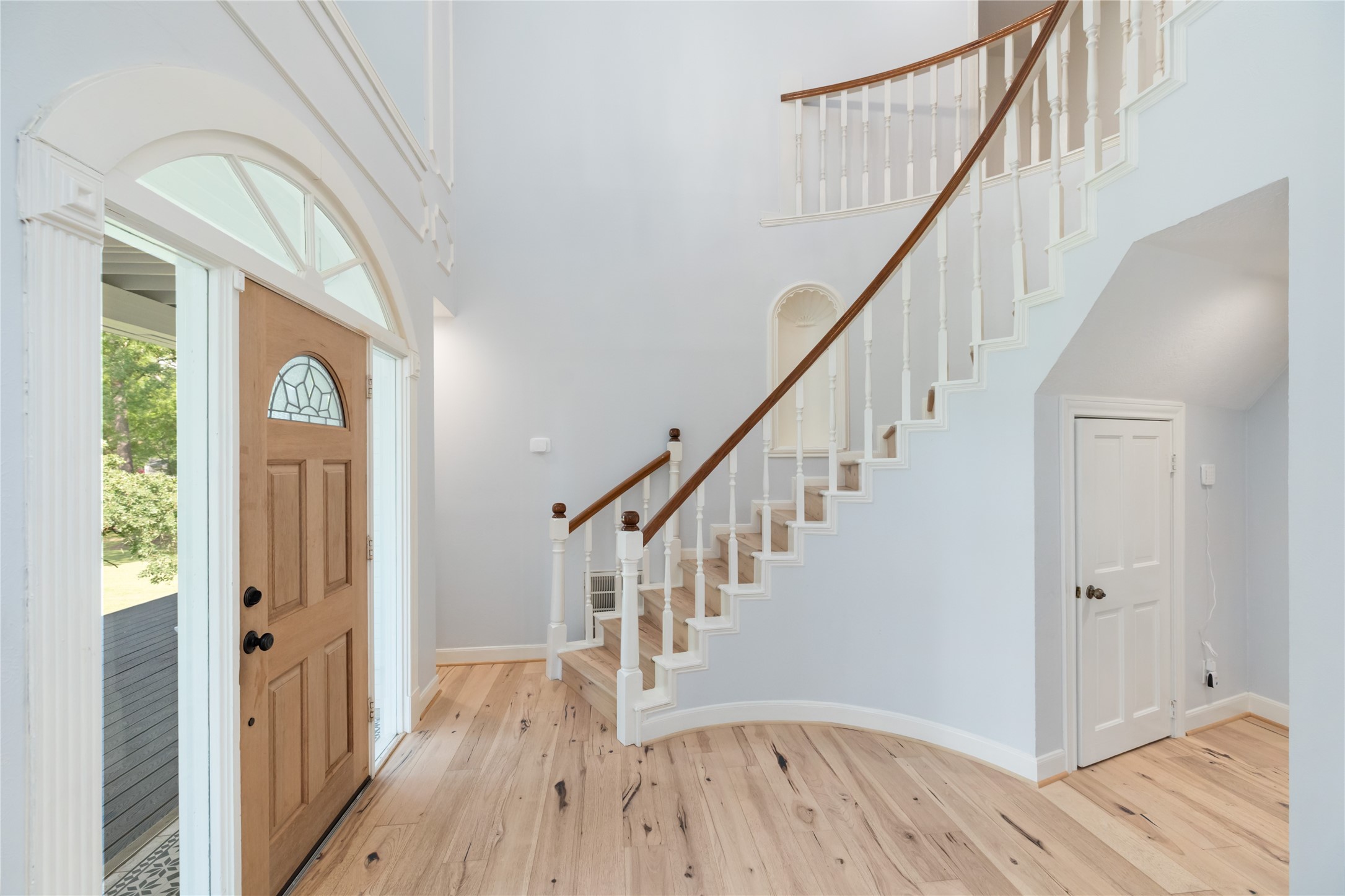 17003 Creeksouth Road Houston, TX 77068 - Photo 11 of 49 Natural light pours in through the transom window and surrounding glass, creating a bright and welcoming entry. Cleverly designed storage under the staircase adds both function and charm.