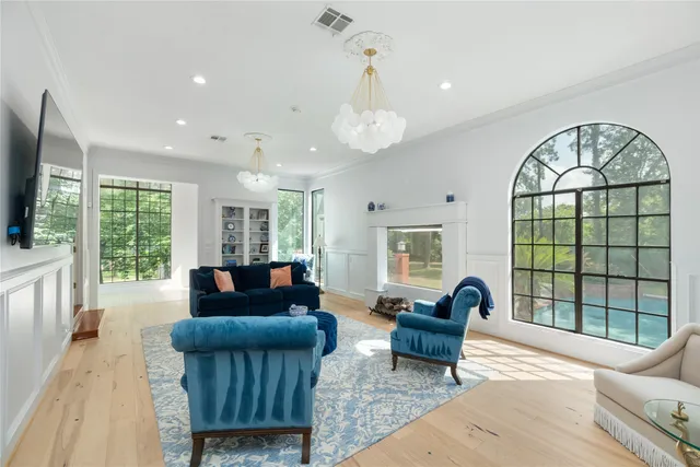 a living room with furniture a flat screen tv and a large window