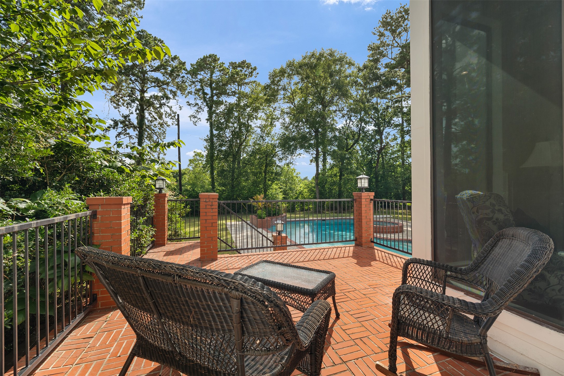 17003 Creeksouth Road Houston, TX 77068 - Photo 17 of 49 A sunny, tranquil retreat, this charming brick patio overlooks the sparkling pool, offering the perfect spot to relax, entertain, or simply enjoy peaceful moments outdoors.