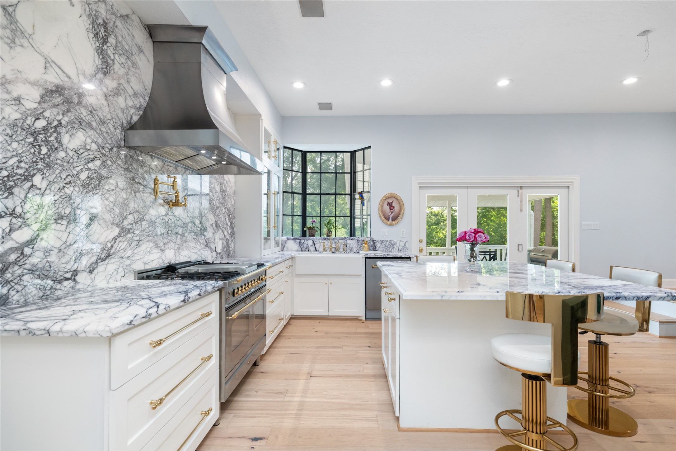 17003 Creeksouth Road Houston, TX 77068 - Photo 21 of 49 White cabinetry accented with gold hardware perfectly complements the striking marble countertops and backsplash, creating a bright and sophisticated culinary space filled with elegance and warmth.