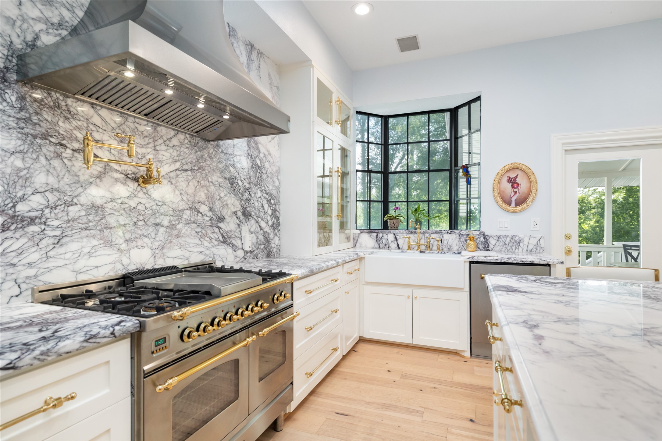 17003 Creeksouth Road Houston, TX 77068 - Photo 22 of 49 This glamorous kitchen centers around a professional-grade range from Italy, complete with a sleek pot filler. Paired with custom gold hardware and beautifully crafted cabinetry, the space balances high-end functionality with elegant design. Marble countertops and designer finishes complete this culinary showpiece.
